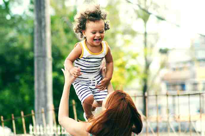 Niño riendo en brazos de su madre